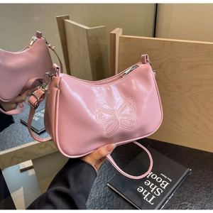 Detailansicht der rosa Baguette-Tasche mit Schmetterlingsprägung und Reißverschluss