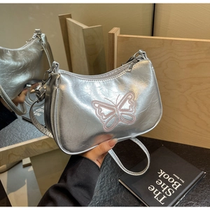 Detailansicht der silbernen Baguette-Tasche mit rosa Schmetterlingsstickerei und Faltenoptik
