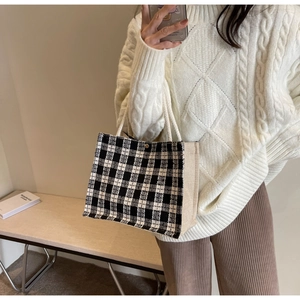 Detail view of checkered canvas tote bag with white cotton rope handle and metal buckle
