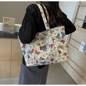 Detail of the large jacquard canvas tote bag featuring colorful butterfly patterns