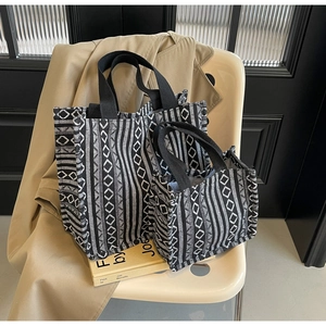Detailed set of black and white geometric ethnic tote bags on a beige chair