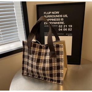 Close-up of retro plaid fabric tote bag on a metal table with soft window lighting