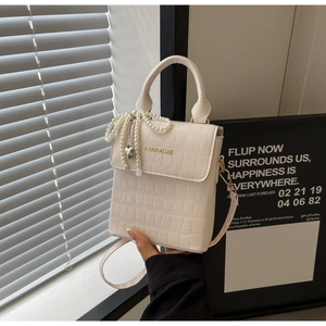 Detail of cream white croc-effect crossbody bag with pearl chain and heart pendant