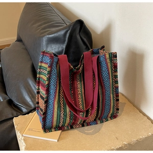 Ethnic woven tote bag with colorful geometric stripes and durable burgundy webbing handles