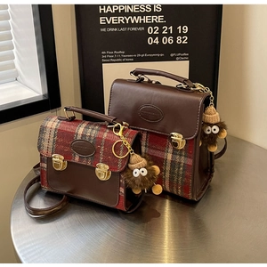 Detailed view of vintage plaid satchel bags in brown with cute plush monster charms