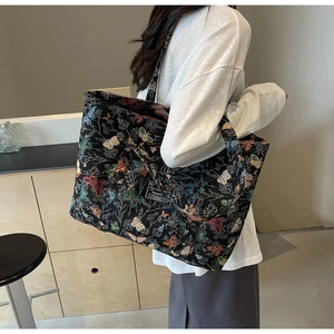 Large black canvas tote bag with colorful butterfly patterns and fashion label patch