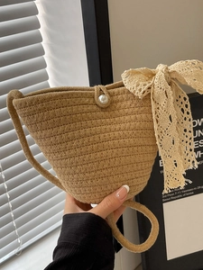Handmade woven crossbody bucket bag with pearl closure and lace bow accessory