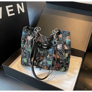 Detailed view of butterfly jacquard tote bag with leather handles in a gift box