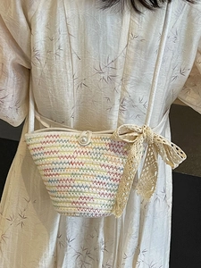 White hand-woven crossbody bag with colorful patterns and a large lace bow decoration