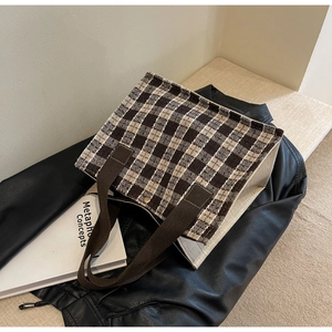 Close-up of checkerboard tote bag featuring woven texture and thick canvas handles