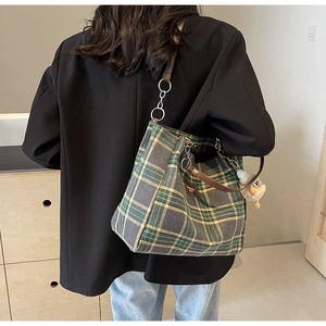 Detail of British vintage plaid tote bag with brown leather straps and fashion label