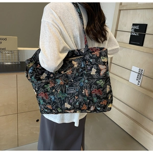 Detail of colorful butterfly jacquard embroidery on large black canvas tote bag