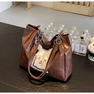 Detail of retro brown tote bag with white cat print and sturdy metal ring strap connectors