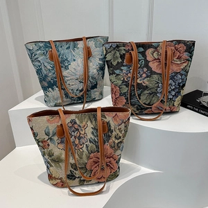 Grandi borse tote in jacquard con motivi floreali e manici in pelle su gradini bianchi