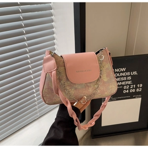 Détail du sac baguette rose en jacquard avec chaîne florale argentée et bandoulière tissée