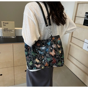 Close-up of a floral butterfly print tote bag with stylish metal chain straps