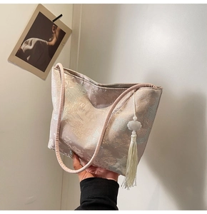 Dettaglio della borsa tote in jacquard floreale con nappa tradizionale e tracolla