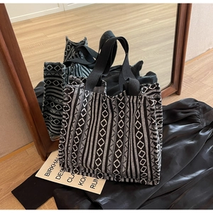 Detail of bohemian tote bag with black and white geometric patterns and woven handles