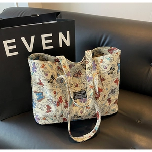 Close-up of colorful butterfly jacquard texture and woven label on a cream tote bag