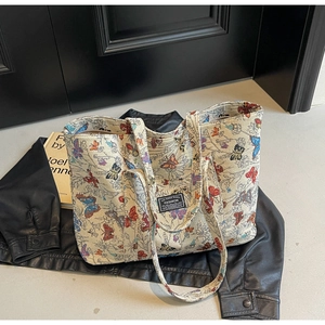 Detail of floral canvas tote bag with butterfly patterns and rectangular fashion label