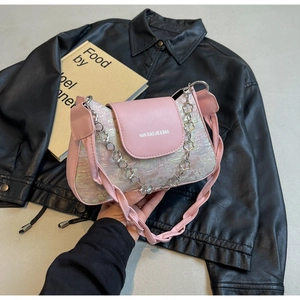 Détail du sac sous le bras floral rose avec chaîne fleurie argentée et bandoulière tressée