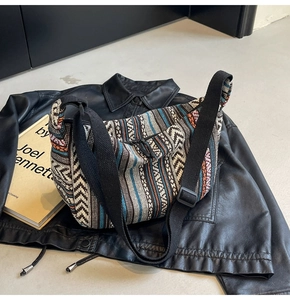 Détail d'un sac bandoulière ethnique tissé aux motifs géométriques sur une veste en cuir