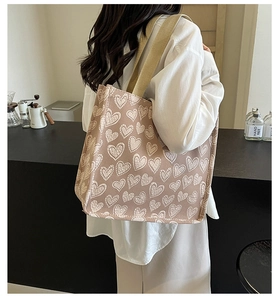 Modella che indossa una borsa tote in tela con motivo a cuori vista dal retro
