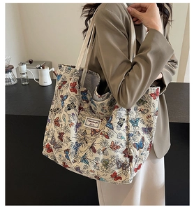 Detail of colorful butterfly prints on large canvas tote bag during daily commute