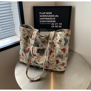 Detail of premium beige tote bag with colorful butterfly prints and fashion label