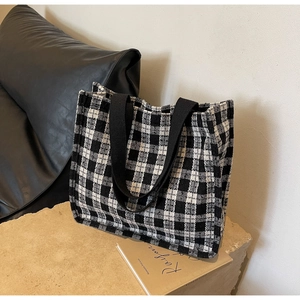 Detailed view of the woven texture and black and white checkerboard pattern of the tote bag