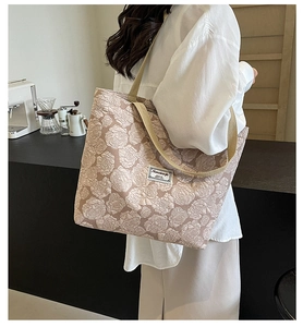 Detail of vintage rose jacquard tote bag with textured floral pattern and woven handles