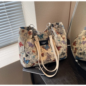Detail of colorful butterfly pattern tote bag with leather straps and metal hardware