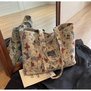 Detail view showing retro jacquard fabric with colorful butterfly embroidery on tote bag