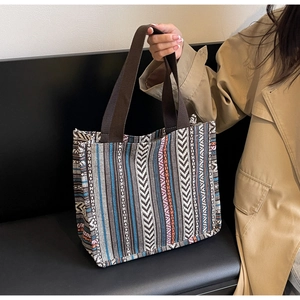Close-up of woven ethnic tote bag featuring vibrant geometric patterns and canvas handles