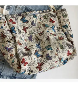 Detail of vintage canvas tote bag with colorful butterfly embroidery and white handles