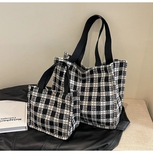 Detail of woven black and white checkered tote bags in two sizes with fabric texture
