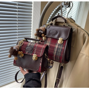 Detail of vintage plaid handbag with gold clasp, PU leather trim, and plush charm