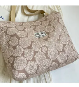 Close-up of beige jacquard tote bag featuring intricate floral rose texture and canvas handles