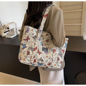 Detail of canvas tote bag with butterfly embroidery and Fashion label on woven fabric