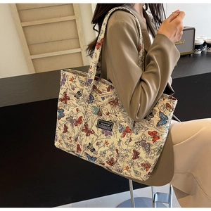 Detail of multi-colored butterfly print and fashion label on large canvas tote bag