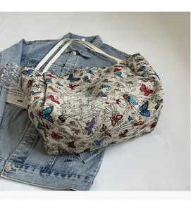 Detail of canvas tote bag with butterfly patterns on light blue denim jacket background