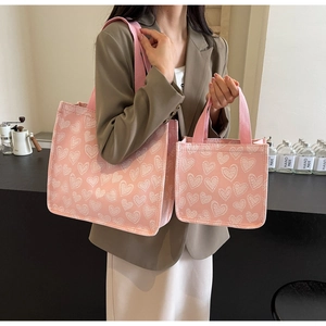 Dettaglio del set di borse tote in tela rosa con motivo jacquard a cuori