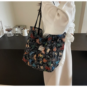 Detail of colorful butterfly print on large black canvas tote bag with shoulder strap