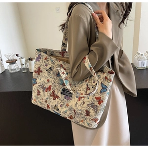 Detailed view of canvas tote bag with vibrant butterfly prints and fashion label