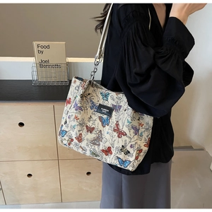 Detail of colorful butterfly print canvas tote bag with leather strap and metal chain