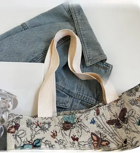 Top view of woven tote bag with blue butterfly jacquard pattern and thick canvas handles
