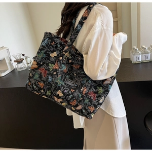 Detail of colorful butterfly pattern canvas tote bag with fashion tag on a black surface