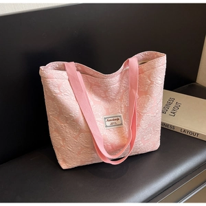 Close-up of pink rose jacquard texture and woven strap on a large canvas tote bag