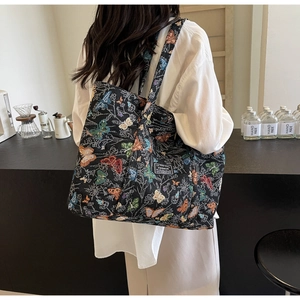 Detail of the colorful butterfly print and woven texture on a black tote bag