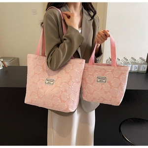 Detailed view of pink rose embossed fabric texture on a large canvas tote and handbag